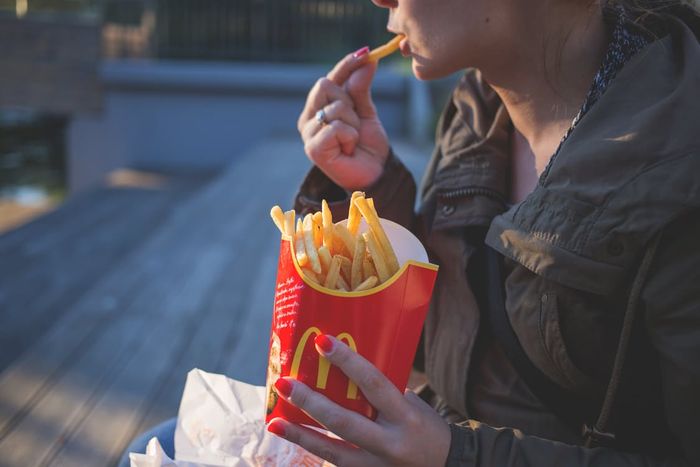 femme en train de manger des frites McDonalds pour illustrer la livraison à domicile de McDonalds lancé en janvier 2017 en Floride