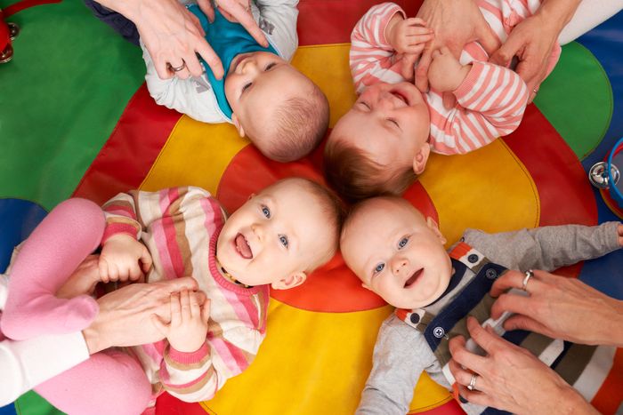 bébés riant sur un tapis en crèche