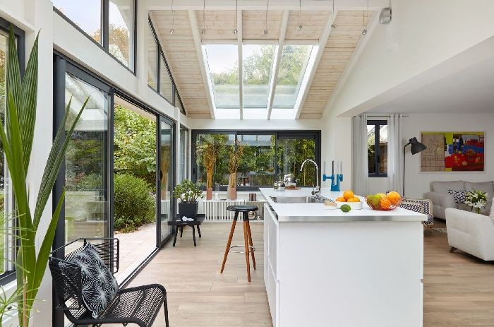 Lumière sur la star de la maison, la cuisine ouverte grâce à une véranda de la gamme Azur de Vie & Véranda